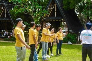 Tim perusahaan sedang melakukan kegiatan outbound training di area hijau Jakarta dengan instruktur profesional memandu aktivitas team building