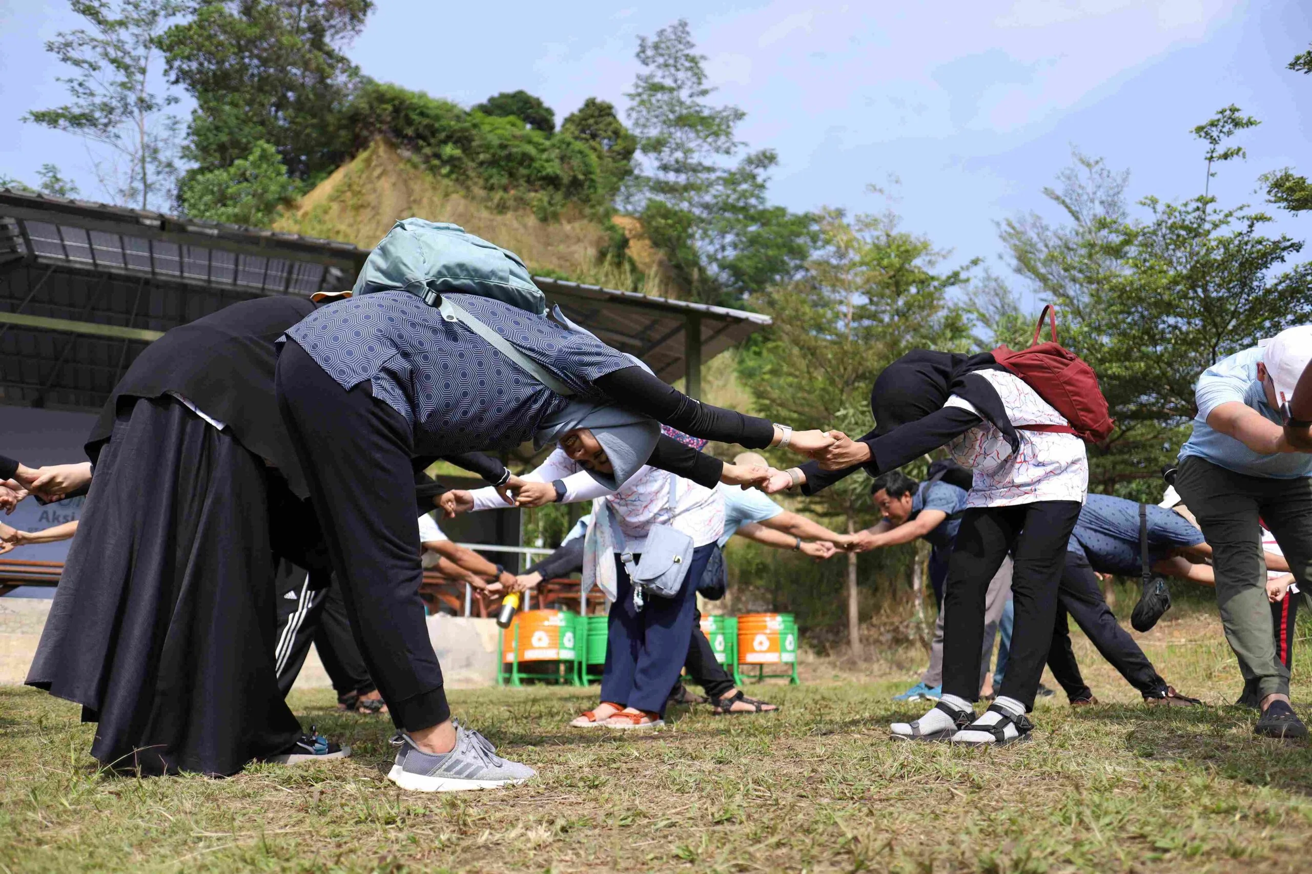 Sekelompok anak muda sedang berkumpul outdoor dalam kegiatan capacity building untuk melatih teamwork dan leadership skill.